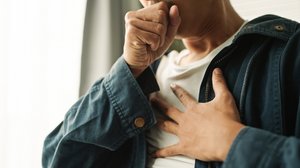 Persn greift sich mit der Hand an den Brustkorb