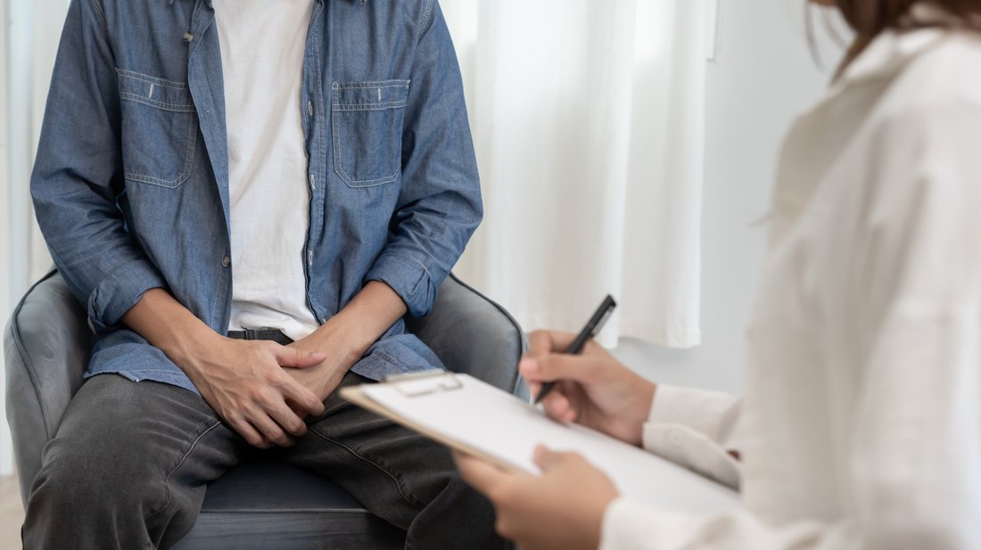 Arzt im Patientengespräch mit Block in der Hand