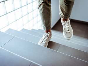 Männliche Füße in Sneaker Schuhen beim Treppe hinauf gehen