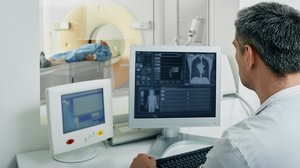 Arzt vor Bildschirm mit CT-Scan